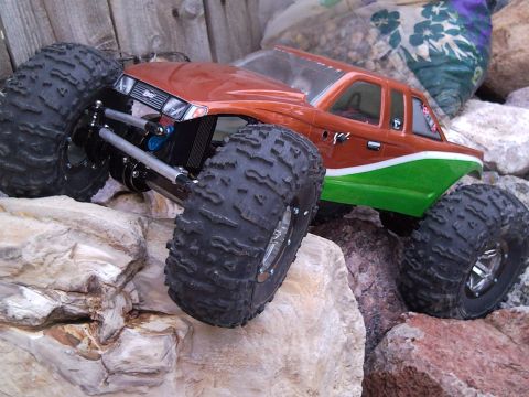 1989 Ford Bronco - This RC rock crawler truck is positioned on a rocky surface, with its large tires visible.