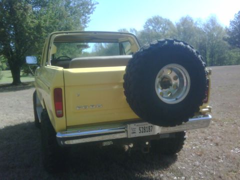 1978 Ford Bronco - Rear view of a yellow 1978 Ford Bronco, showing the spare tire and tailgate.