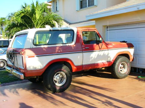 1995 Ford Bronco - This two-tone Ford Bronco is parked in front of a garage with palm trees nearby.