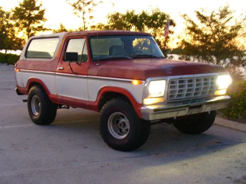 1995 Ford Bronco - This two-tone red and white Ford Bronco from the late 1970s is shown in a three-quarter front view.