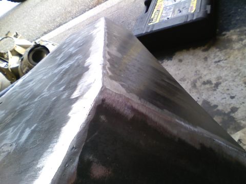 1990 Ford Bronco - Close-up of a metal corner showing grinding marks, with an oil bottle visible in the background.