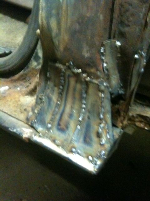 1993 Ford Bronco - Close-up view of a heavily welded and rusted metal frame section.
