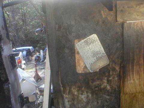 1998 GMC Sierra 3500 - A white pickup truck is visible in the background, partially obscured by debris and within a structure.