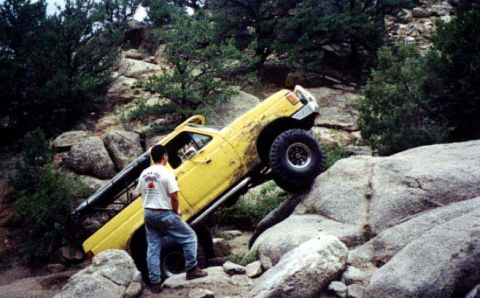 2002 Ford F-350 - Off-road pickup truck attempts to climb a steep, rocky terrain.