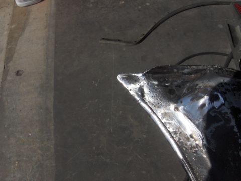 1980 Chevrolet Camaro - This photo shows a close-up of a car fender undergoing repair work, with visible metal shaping and primer.