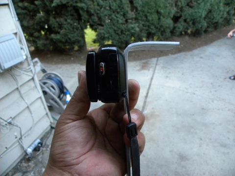 1995 Ford Bronco - A hand holds a black digital camera with a wrist strap attached.