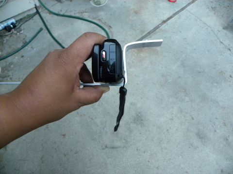 1995 Ford Bronco - A digital camera is mounted on a custom metal bracket, held by a person's hand.