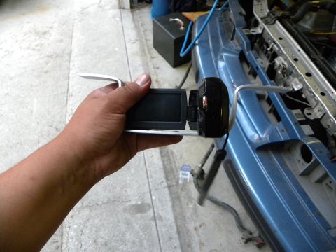 1995 Ford Bronco - Camcorder held in front of a vehicle's front end, possibly for recording repairs or modifications.