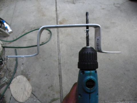 1995 Ford Bronco - A metal bracket is positioned with a drill bit, ready for use.