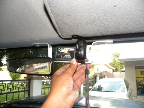 1995 Ford Bronco - A dashcam is mounted on the windshield, with a rearview mirror reflecting a car and a second car visible through the windshield.