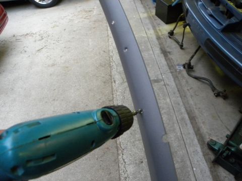 1995 Ford Bronco - Drilling a hole in a car's interior trim panel.
