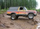 1978 Ford Bronco - This 1978 Ford Bronco, distinctive sunset graphics, navigates a challenging muddy terrain.