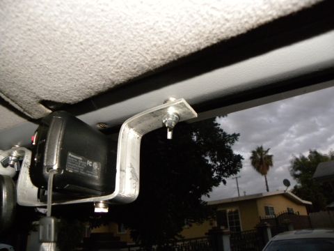 1995 Ford Bronco - A Panasonic camcorder is mounted on a metal bracket inside a vehicle, with a cloudy sky visible through the window.
