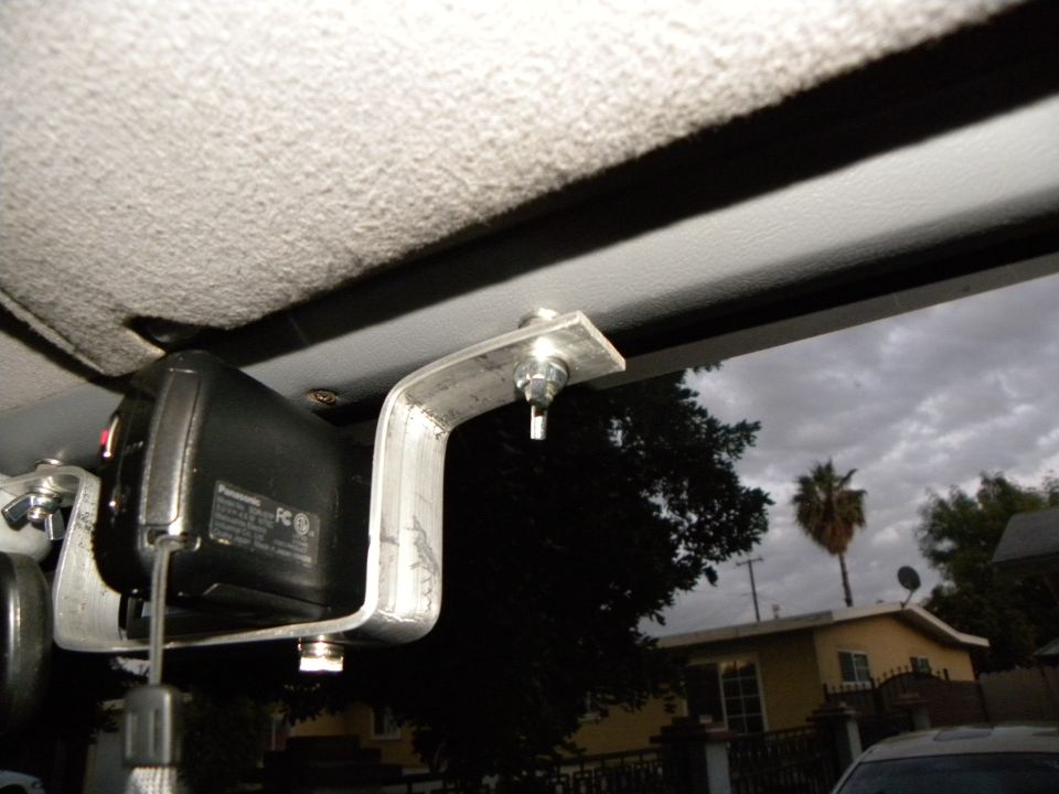 Panasonic camcorder mounted on metal bracket inside vehicle