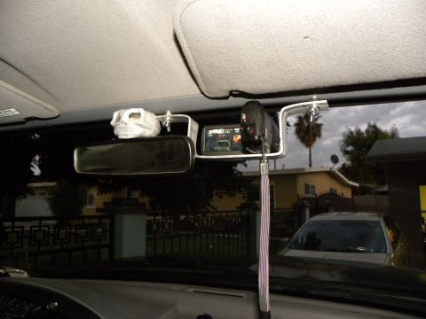 1995 Ford Bronco - Vehicle interior with skull ornament and dashcam; another car is visible outside.
