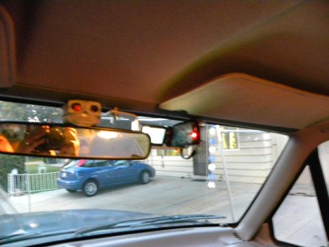 1995 Ford Bronco - View from inside a vehicle shows a blue sedan parked in a driveway.