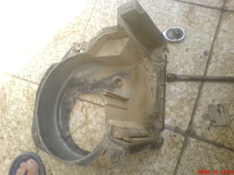 1998 Ford Crown Victoria - A dirty fan shroud and a socket wrench are on a tiled surface, suggesting a car part removal or repair.
