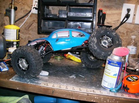 1989 Ford Bronco - A blue remote control car sits on a workbench next to tools and spray cans.