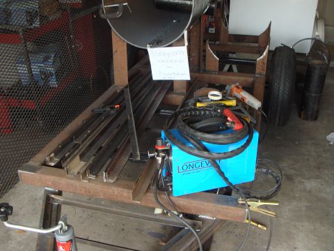 1992 Ford Bronco - A scene depicting welding equipment and metal stock, with a tire visible in the background.