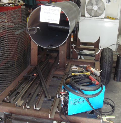 1992 Ford Bronco - Metal pipe assembly on a welding cart with various tools and equipment.