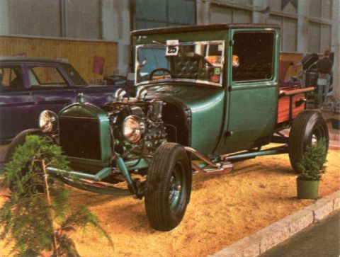 1969 Lincoln Continental - This modified pickup truck features an exposed engine and a wooden bed, displayed indoors.