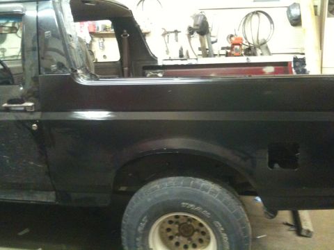 1993 Ford Bronco - Side view of a 1993 Ford Bronco, focusing on the rear quarter panel and wheel.