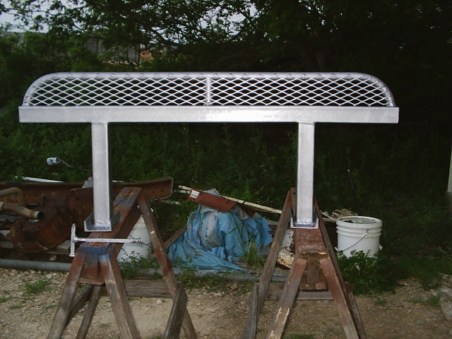 Galvanized metal mesh platform on posts atop sawhorses outdoors