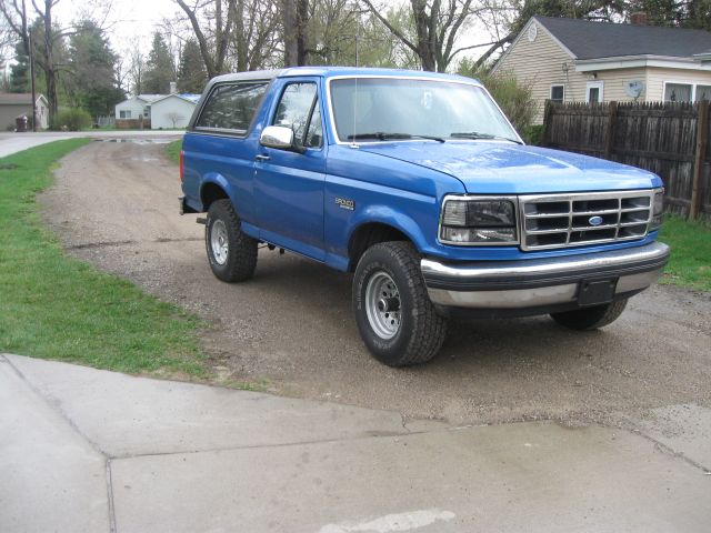 Blue 1992 Ford Bronco parked on a dirt driveway