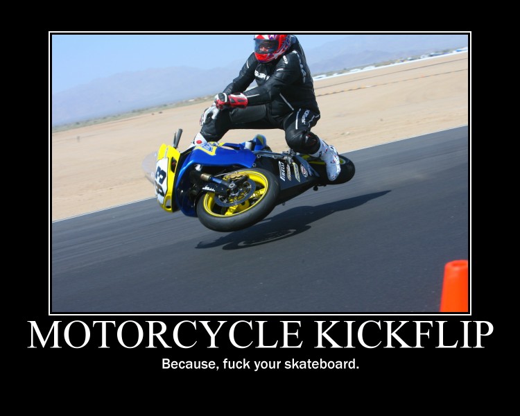Motorcycle doing a wheelie on a race track with a rider in full gear