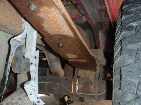 1995 Ford Bronco - Close-up view of the undercarriage, focusing on the suspension system and a tire.