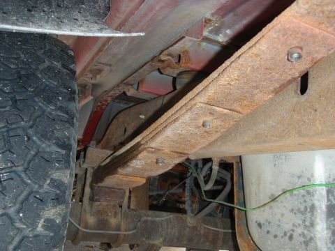 1995 Ford Bronco - The undercarriage of a 1995 Ford Bronco reveals its leaf spring suspension system and a portion of the rear tire.