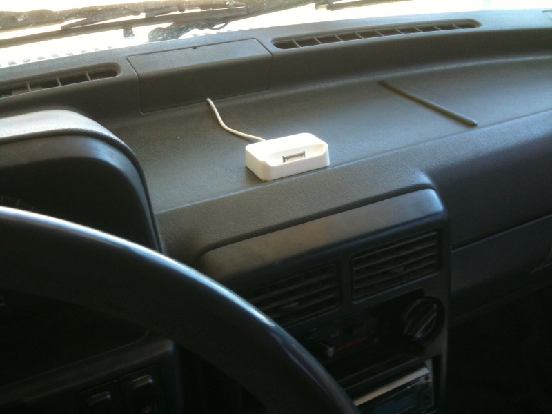 Interior dashboard with a white charging dock plugged into a power outlet