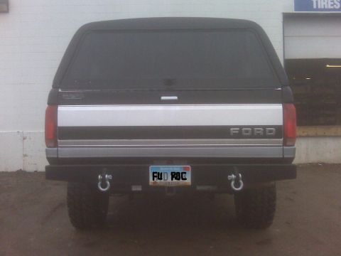 1994 Ford F-150 - Rear view of a Ford pickup truck, likely from the early to mid-1990s, equipped with a camper shell and aftermarket bumper.
