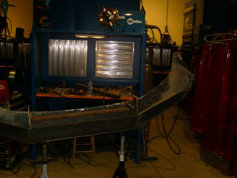 2000 Dodge 1500 - A custom metal bumper is being fabricated in a workshop with welding equipment visible.