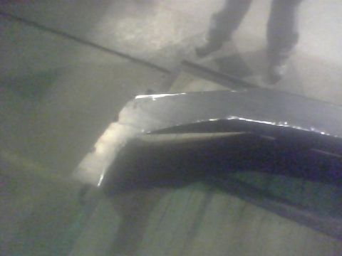 2000 Dodge 1500 - A damaged truck bed shows reflective trim and the legs of two individuals standing nearby.