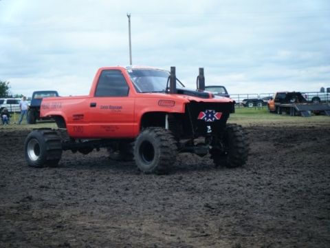 2000 Dodge 1500 - Modified pickup truck with custom front grille and exhaust stacks sits in a muddy area.