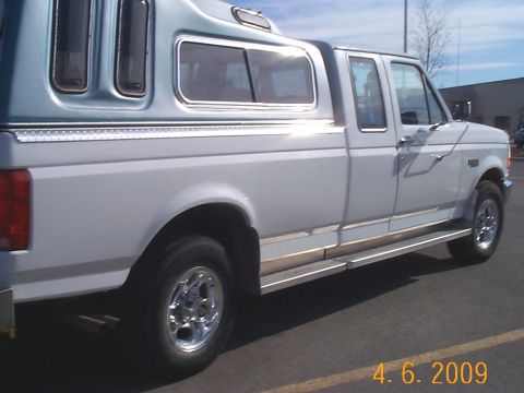 1995 Ford F-250 - This white Ford F-250 Super Duty pickup truck is equipped with a blue camper shell.