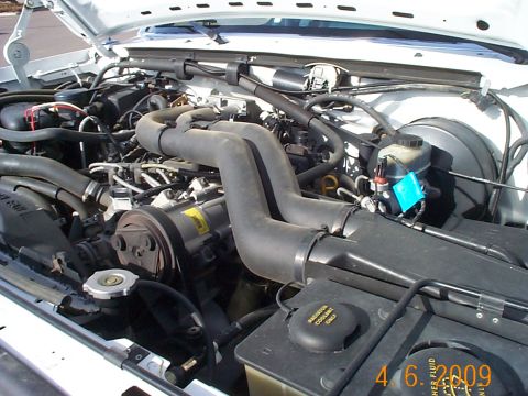 1995 Ford F-250 - The engine bay of a 1995 Ford F-250 pickup truck is shown with the hood raised.