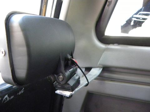 1995 Ford Bronco - Close-up of an aftermarket mirror attachment inside a vehicle's door panel.