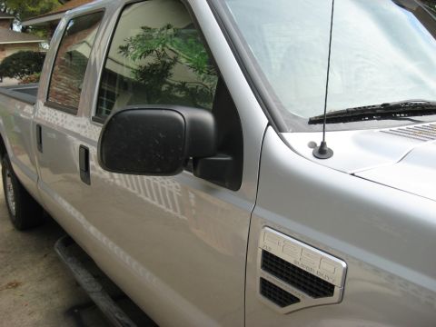 2008 Ford F-250 - Driver's side view of a silver 2008 Ford F-250 Super Duty truck, highlighting the fender badge.