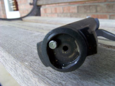1995 Mercury Grand Marquis - Black tool part with silver pin and hole on wooden surface.