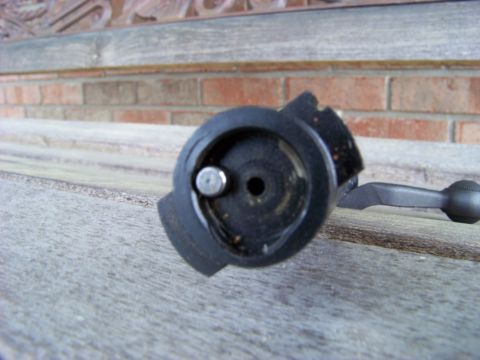 1995 Mercury Grand Marquis - Close-up of a bolt action mechanism, likely from a firearm, resting on a wooden surface.