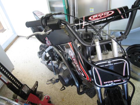 1986 Ford Bronco - A mini dirt bike is shown with graphics on its handlebars and front plate.
