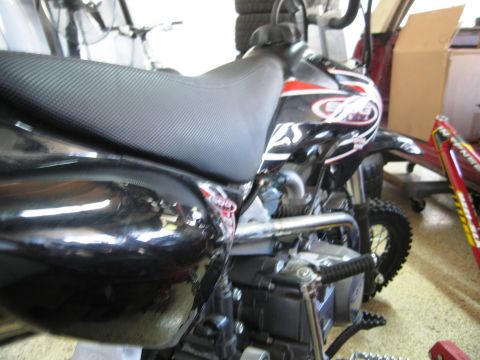 1986 Ford Bronco - A black dirt bike is shown from the side, red and white graphics on its body panels.