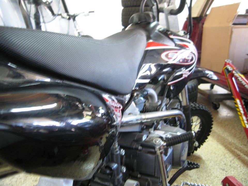 Black dirt bike side view with red and white graphics