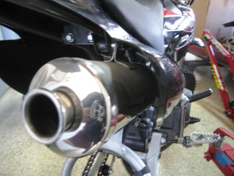 1986 Ford Bronco - Detail shot of a motorcycle's exhaust system, showing the chrome muffler and surrounding components.