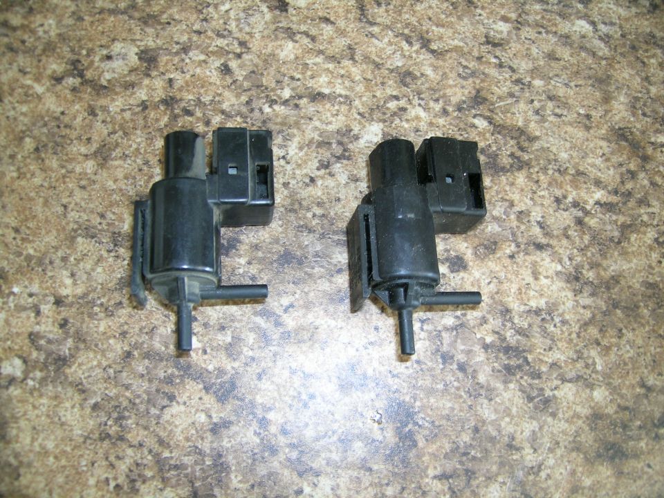 Two black plastic vacuum actuators with electrical connectors