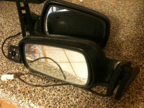 1991 Ford Festiva - A pair of black side mirrors, likely for a car, are shown with their electrical wiring and adjustment controls visible.