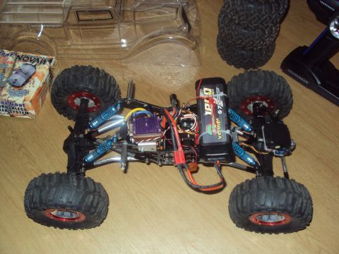 1992 Ford Ranger - A remote-controlled rock crawler chassis is shown with its battery pack, electronic components, and a remote control.
