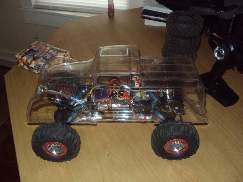 1992 Ford Ranger - RC truck with clear body and visible internal components, next to its remote control transmitter.